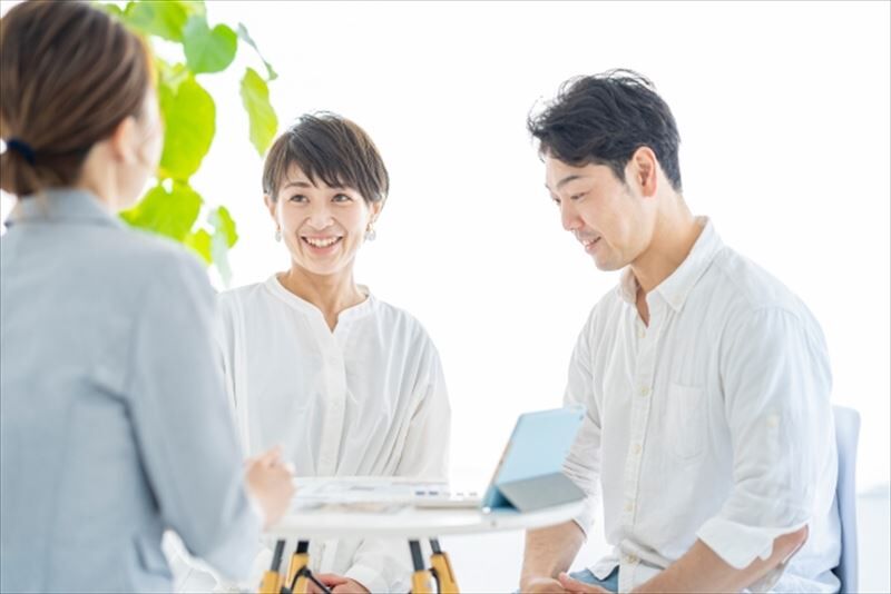 211015_スーツ姿の女性から説明を受ける夫婦S
